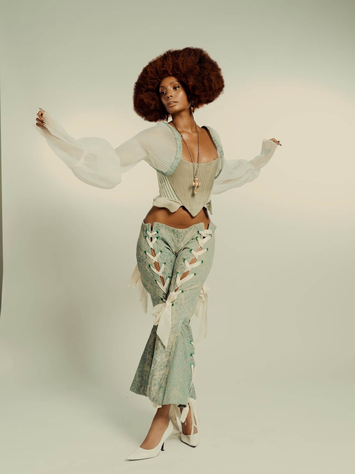 Beautiful black woman with an afro in bell bottoms and white heels